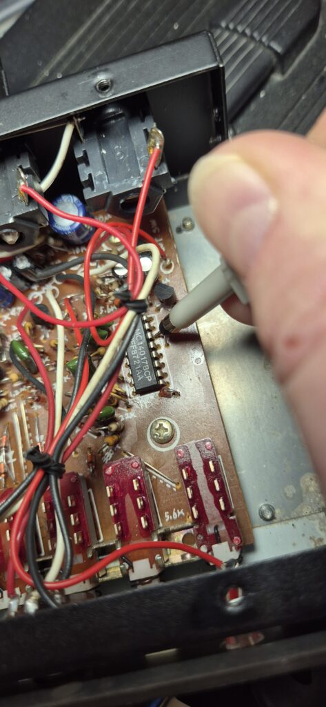 A oscilloscope probe probing one pin of the CD4017 clock divider IC on the AK-Drummer CRM-260